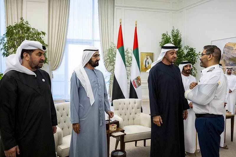 UAE leaders greet a flydubai crew member at an indoor reception.